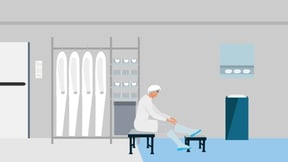 A cleanroom operator is donning in a gowning room.